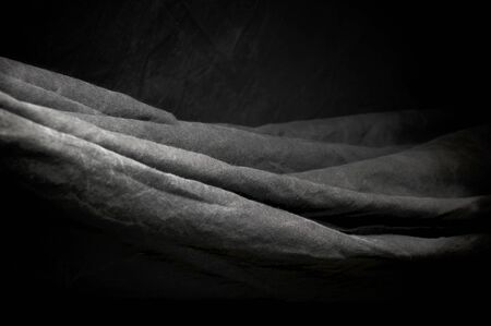 horizontal over lapping folds of black photography studio background cloth.の写真素材