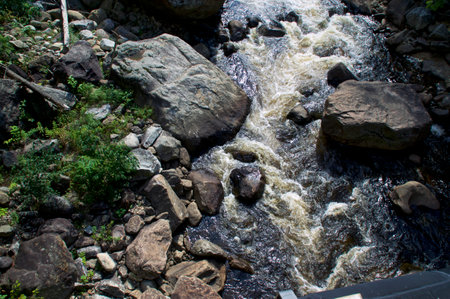 Looking down at rocky river in wilmington new york wilderness, with water rushing over large boulders.の写真素材