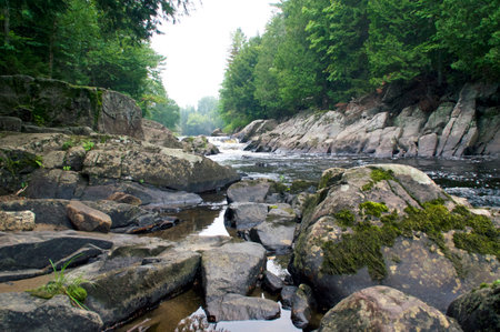 Low angle view over large boulders of beautiful waterfall and flowing stream in Wilmington New York, Lake Placid Adirondack Region.の写真素材