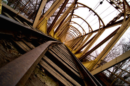 Old rusty iron bridge over the river, perspective view, close up