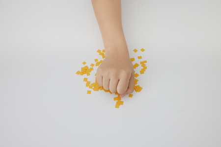 Hands of a child playing with puzzle pieces on a white backgroundの写真素材