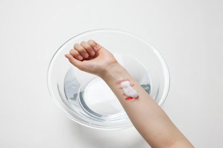 Close up of female hand with bandage on her arm against white backgroundの写真素材