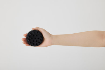 Hand holding a black plastic coffee filter isolated on a white background.の写真素材