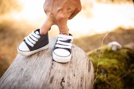 fingers walking with baby shoesの写真素材