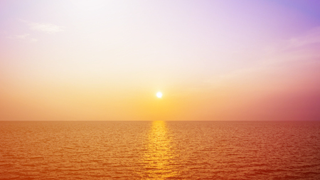 the sun shines golden in the evening on sea.の写真素材