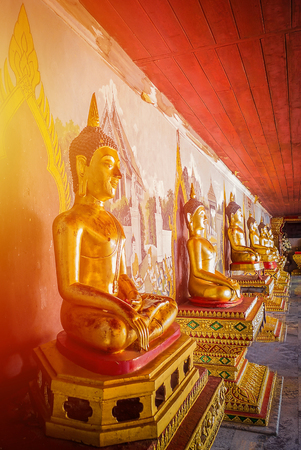 The elegance of the Golden Buddha statue with Orange light.の写真素材
