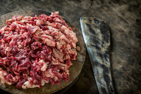 Shredded Raw beef on the cutting board with knife.の写真素材