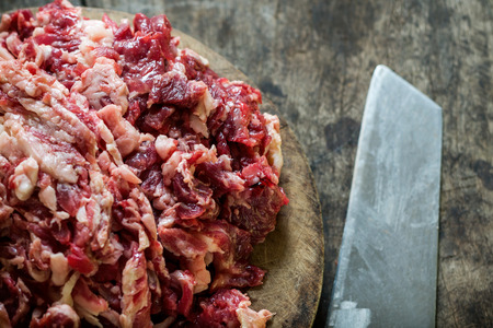 Shredded Raw beef on the cutting board with knife.の写真素材