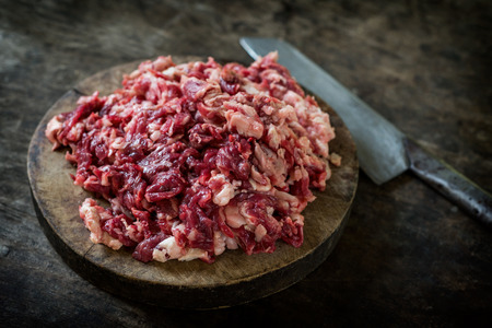 Shredded Raw beef on the cutting board with knife.の写真素材