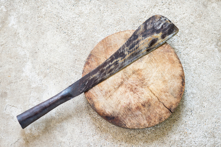 cutting board with old knife on floor.の写真素材
