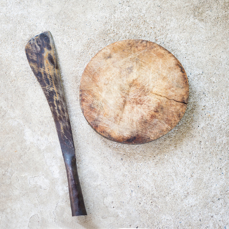 cutting board with old knife on floor.の写真素材