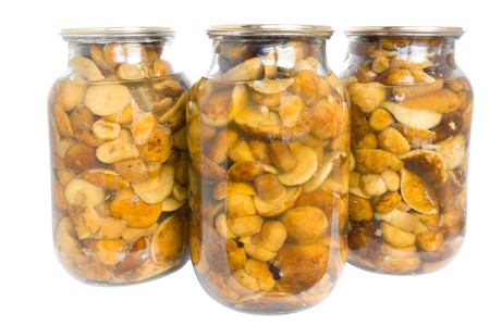 Glass jar of preserved mushroom isolated in whiteの写真素材