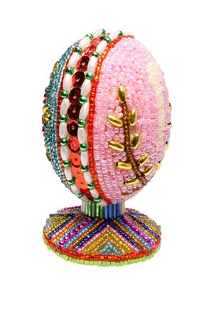 An easter egg is decorated a bead on a white backgroundの写真素材