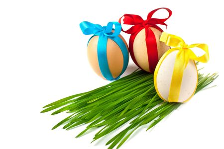 decorated easter eggs in the grass on a white backgroundの写真素材