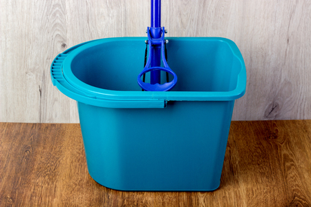 mop and blue bucket on the floorの写真素材