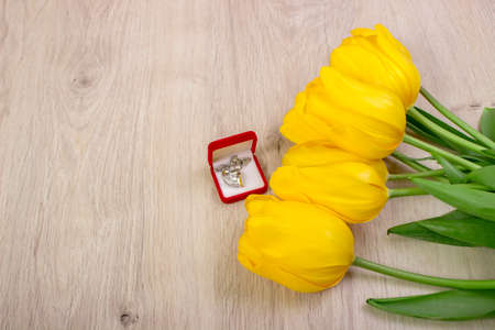 Yellow, fresh tulips with gift on a wooden table.の写真素材