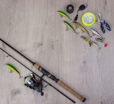 Fishing tackle - fishing spinning, hooks and lures on light wooden background.Top view.の写真素材