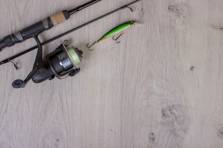Fishing tackle - fishing spinning, hooks and lures on light wooden background.Top view.の写真素材