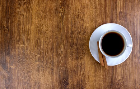 coffee cup, cinnamon sticks, wooden table backgroundの写真素材