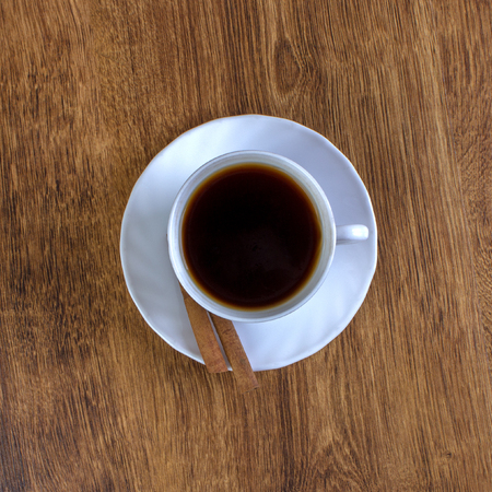 coffee cup, cinnamon sticks, wooden table backgroundの写真素材