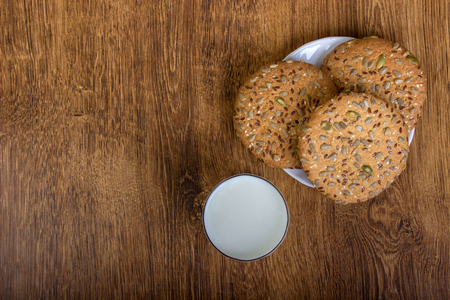 The composition of biscuits and a glass jar with milk. Cookies and milk white yogurt, on a white background with reflection. Tasty yellow brown cookies. Yogurt and oatmeal cookies.の写真素材