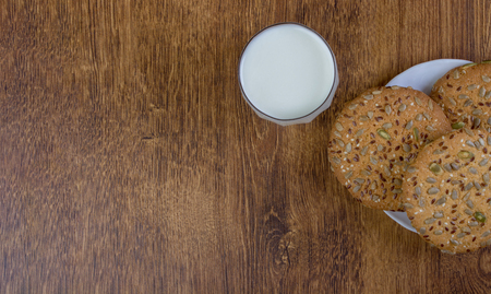 The composition of biscuits and a glass jar with milk. Cookies and milk white yogurt, on a white background with reflection. Tasty yellow brown cookies. Yogurt and oatmeal cookies.の写真素材