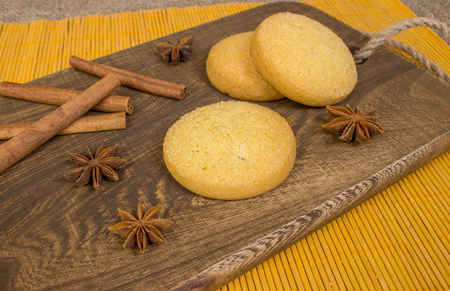 homemade gingerbread cookies, spices and cutting board on wooden background. holiday, celebration and cooking concept.の写真素材