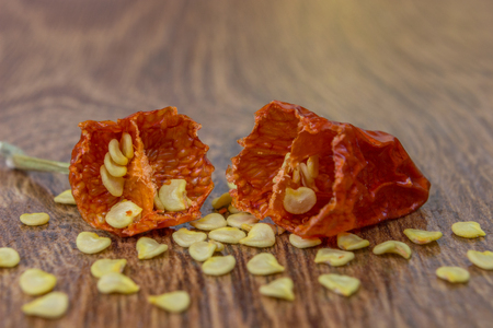 cut, small dried red peppers with seeds on a wood background, close-uの写真素材