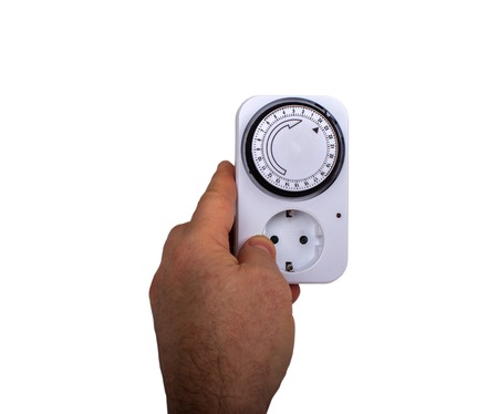 Man Adjusting Timer On Electrical Socket isolatedの写真素材
