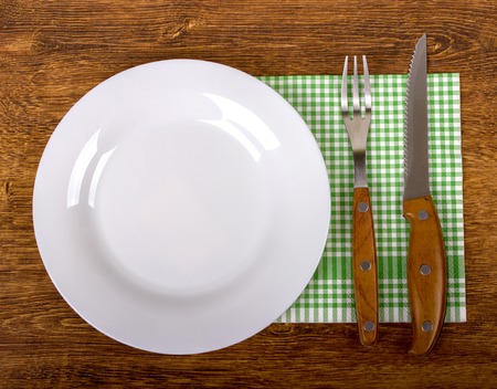 Empty Plate, Fork and Knife on wooden background. Top View with Text Spaceの写真素材