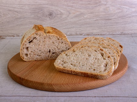 Fresh rectangular bread sliced on a wooden boardの写真素材