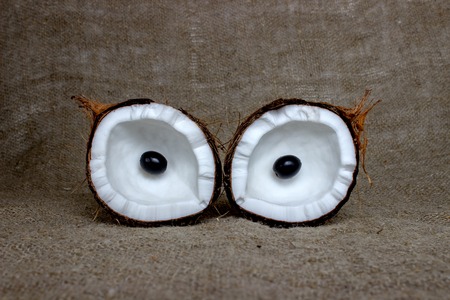 coconut cut into pieces on burlap. Halves of coconut in a owl eyesの写真素材