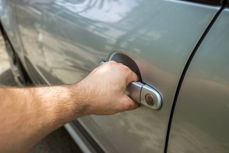 Close up of human male hand opening car doorの写真素材