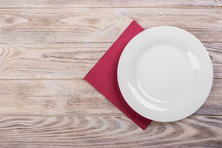 Empty plate on wooden tabletop with tableclothの写真素材