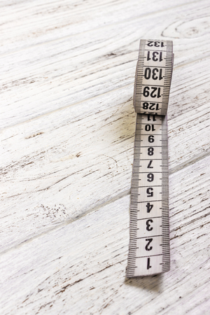 sartorial meter and scissors on the old wooden backgroundの写真素材