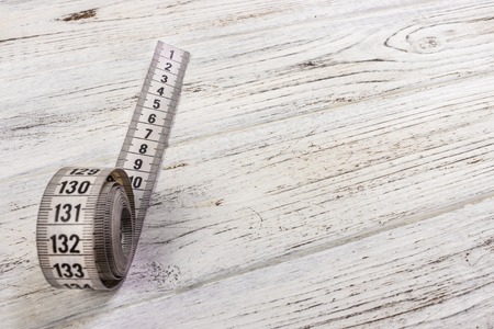 sartorial meter and scissors on the old wooden backgroundの写真素材