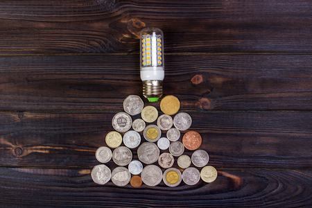 light bulb on over pile of coins - money, finance, savings concept and ideaの写真素材