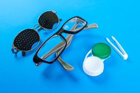 A set of accessories for sight. Pinhole glasses, lenses with container and glasses for sight. Pair...