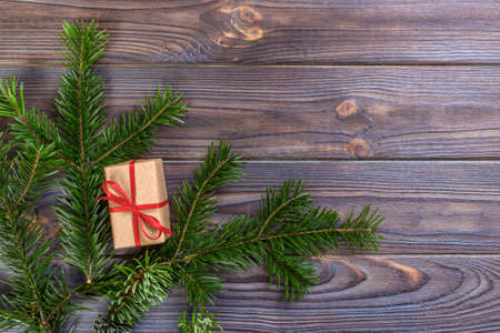 Wrapped Christmas gifts on dark rustic wooden table fir branches. With copy space for your text.の写真素材