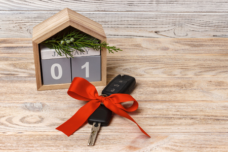 Close-up view of car keys with red bow as present and calendar on wooden background on wooden background.の写真素材