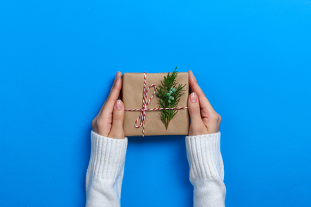 Female hands holding gift box on Blue background.の写真素材