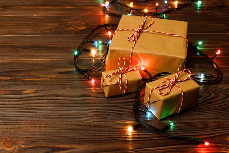 Christmas tree lights on the floor all around a nicely wrapped group of present boxes set under a Christmas tree.の写真素材