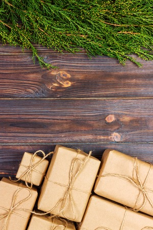 Many gift box on dark rustic wooden background with copy space. Christmas fir tree branches....