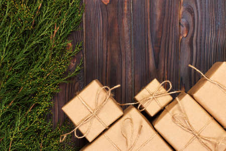 Christmas fir tree branches with gift box on dark rustic wooden background with copy space for text.の写真素材
