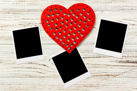 Instant photo with wooden heart on old wooden background.の写真素材