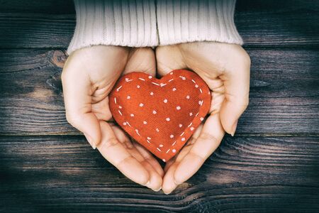 Girl hand holding red heart shape vintage tone.