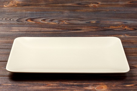 Blank rectangular plate on wooden background. top view.