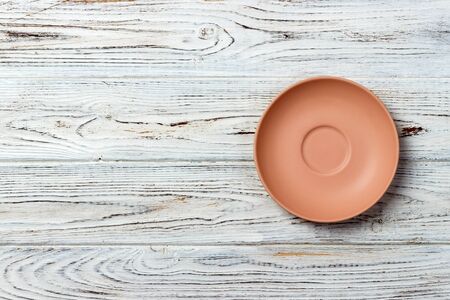 Orange round plate top view on a background of old wood table plank. matte round plate.の写真素材