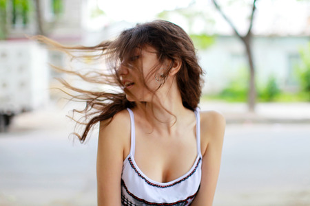 Girl with flying hair on the street.の写真素材