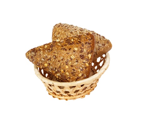 Closeup of rye bread with flax seeds on basket isolated on white background.の写真素材